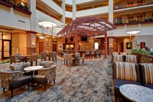 温泉城Embassy Suites by Hilton at Hot Springs Convention Center的酒店大堂里摆放着桌椅
