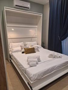 un letto bianco con asciugamani in una stanza di DOMUS 0143 a San Giorgio Ionico