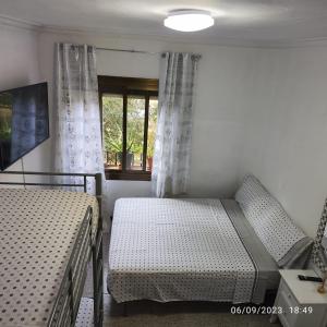 a bedroom with two beds and a window at Apto Barcelona C R in Santa Coloma de Gramanet