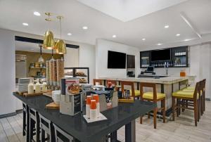 una cocina con una gran mesa negra con sillas amarillas en Hilton Garden Inn Houston/Galleria Area, en Houston