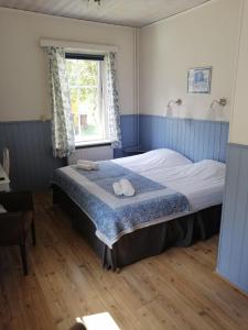 Schlafzimmer mit einem Bett und einem Fenster in der Unterkunft Värdshuset Lugnet in Malung