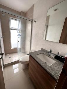 y baño con lavabo, aseo y espejo. en Departamento de Lujo en con Alberca Panoramica en Zona Metropolitana de Guadalajara en Guadalajara