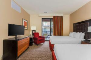 a hotel room with two beds and a flat screen tv at Hilton Promenade Branson Landing in Branson
