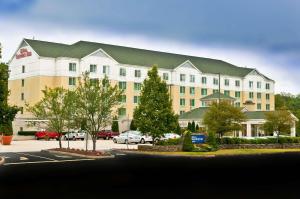 a large white building with a green roof at Hilton Garden Inn Shelton in Shelton