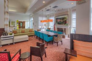 a dining room and living room with a table and chairs at Hilton Garden Inn Shelton in Shelton