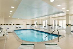 une grande piscine dans un hôpital avec des chaises et des tables dans l'établissement Hilton Garden Inn Shelton, à Shelton