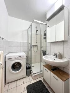 ein Badezimmer mit einer Waschmaschine und einem Waschbecken in der Unterkunft Stilvolles Apartment mit ländlichem Ausblick in Hattingen