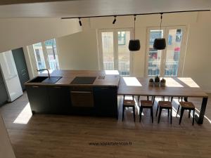 une cuisine avec une table en bois, une table et des chaises dans l'établissement Appart'Alencon, à Aleçon