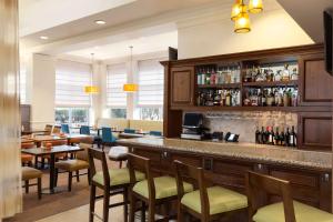 a bar in a restaurant with tables and chairs at Hilton Garden Inn Shelton in Shelton