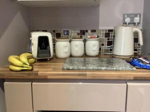 a kitchen counter with bananas on a wooden counter top at The Anfield Apartment in Liverpool