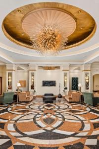 a lobby with a chandelier and a large rug at Conrad Indianapolis in Indianapolis