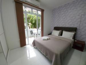 a bedroom with a bed and a large window at Loft aconchegante no Leblon in Rio de Janeiro