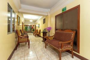 una sala d'attesa con sedie e tavoli e un corridoio di Hotel Malecon Inn a Guayaquil