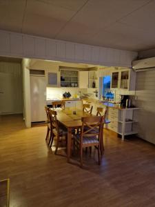 a kitchen and dining room with a table and chairs at Warm and cozy cottage, Great location in Kvaløya