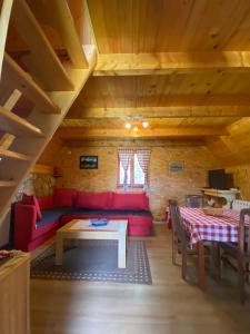 a living room with a red couch and a table at Durmitor Bungalows in Žabljak