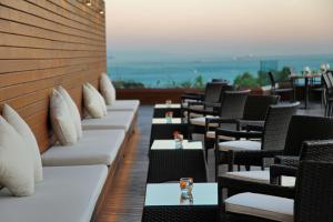 - un restaurant avec des tables et des chaises offrant une vue sur l'océan dans l'établissement Conrad Istanbul Bosphorus, à Istanbul
