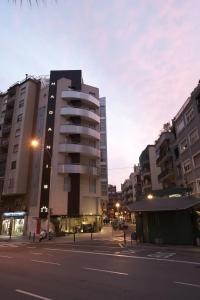 a tall building on a city street with buildings at Hotel Madanis in Barcelona