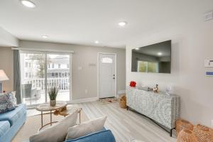 a living room with a blue couch and a table at Wildwood Home with Deck - Walk to Beach and Boardwalk! in Wildwood