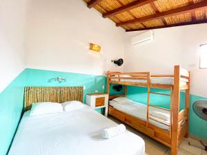 two beds in a room with a bunk bed at Oasis Hostel in Granada