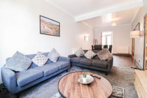 sala de estar con sofá azul y mesa en BIRMINGHAM Cosy Contractor House - FREE WIFI! en Birmingham