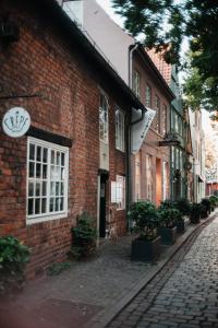 a red brick building on a cobblestone street at Suite Dreams Studio in Bremen