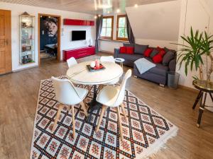 Cozy apartment in Herrischried in a charming area في Herrischried: غرفة معيشة مع طاولة وكراسي وأريكة