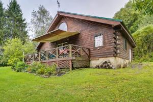 a log cabin with a porch and a large yard at Pet-Friendly Jamestown Cabin with Fire Pit and Deck! in Jamestown
