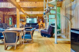 ein Wohnzimmer mit einem Tisch und Stühlen sowie einer Wendeltreppe in der Unterkunft Pet-Friendly Jamestown Cabin with Fire Pit and Deck! in Jamestown