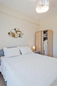 una camera con un grande letto bianco e un armadio di Vènto villa a Karpathos
