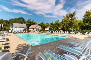 une grande piscine avec des chaises longues dans un complexe hôtelier dans l'établissement Cottage Retreat, à Wells