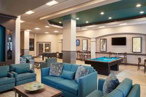 a lobby with blue couches and a pool table at Hilton Grand Vacations Club Paradise Las Vegas in Las Vegas