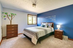 a bedroom with a bed and a blue wall at Bolivar Getaway Near Pro Football Hall of Fame! in Bolivar