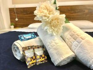 a pile of towels and a flower on a bed at V1118 Maravilhoso flat em hotel de Brasília Central in Brasilia +15 photos
