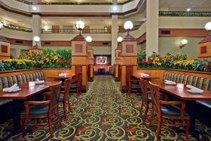 ein Restaurant mit Tischen, Stühlen und Blumen in der Unterkunft Embassy Suites Lexington in Lexington