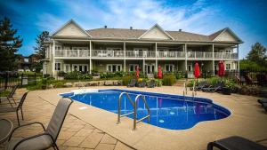 a large house with a swimming pool in front of it at Le 204 Champlain Bromont in Bromont