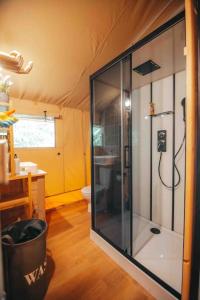 a bathroom with a glass shower in a tent at Cosy Forest Lodge in Penrhôs