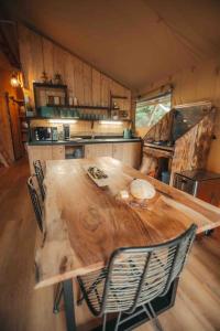 a large wooden table in a kitchen with chairs at Cosy Forest Lodge in Penrhôs