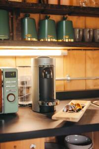 una macchinetta del caffè su un bancone in cucina di Cosy Forest Lodge a Penrhôs