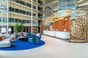 an office lobby with a blue rug and chairs at Hilton London Heathrow Airport in Hillingdon