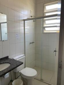 a bathroom with a toilet and a sink and a shower at Canasvieiras Hotel in Florianópolis