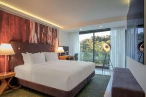 a bedroom with a large bed and a large window at DoubleTree by Hilton Lisbon Fontana Park in Lisbon