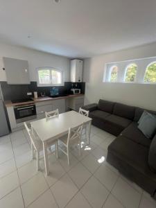 sala de estar con sofá, mesa y cocina en Appartement de charme n7 en Grimaud