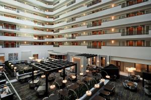 uma imagem de um átrio do hotel com mesas e cadeiras em Embassy Suites Little Rock em Little Rock