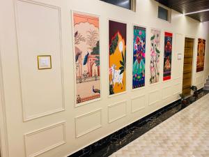 a hallway with colorful paintings on the wall at Golden Lotus Varanasi in Varanasi