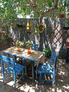 einem Tisch mit zwei blauen Stühlen und einem Tisch mit Pflanzen darauf in der Unterkunft Amorada in Santo Amaro