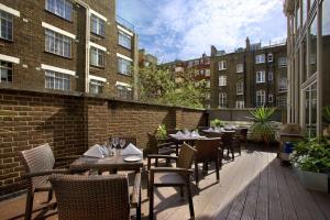 un patio al aire libre con mesas, sillas y edificios en Hilton London Euston en Londres