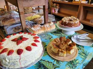 a table topped with cakes and other desserts on plates at Hotel Pousada Parque das Águas in Olímpia