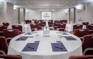 a conference room with white tables and chairs at Hilton London Euston in London