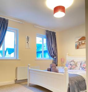 a bedroom with a white bed and two windows at Valentia Skellig Rooms - Knighstown - V23K504 in Valentia Island