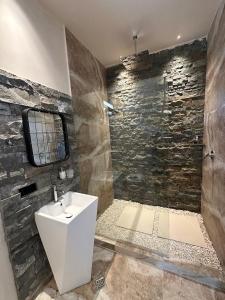 a bathroom with a sink and a stone wall at Alpine Escape Kazbegi in Stepantsminda
